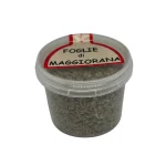 Contenitore con foglie di maggiorana secca pronte all’uso in cucina retro