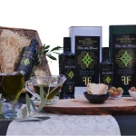 Bottiglie e latte di Olio Extra Vergine di Oliva Terre dei Monaci con pane e olive calabresi